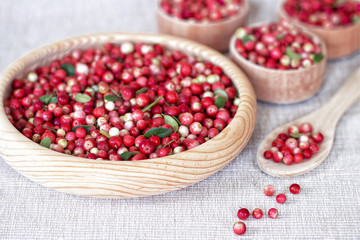 cranberries in wooden bowls on the table close-up. background with cowberry berries.