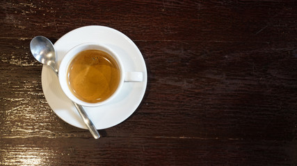 Espresso coffee  in white ceramic cup on wooden table.