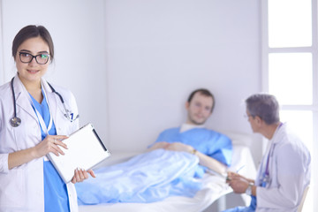 Doctor checking heart beat of patient in bed with stethoscope