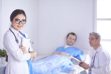 Doctor checking heart beat of patient in bed with stethoscope