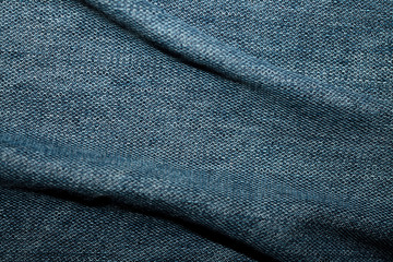 Blue denim texture with bends, background, abstraction. Textile space for text.