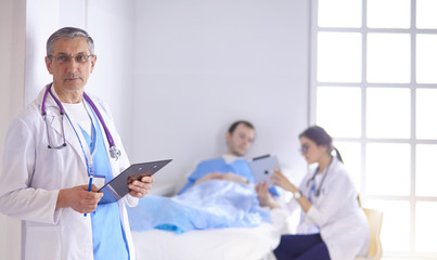 Doctor checking heart beat of patient in bed with stethoscope