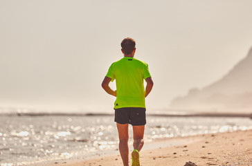 Man running / jogging on a tropical exotic beach.