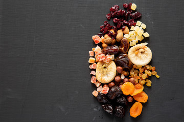 Dried fruits and nut mix on black background, top view. Overhead. Copy space.
