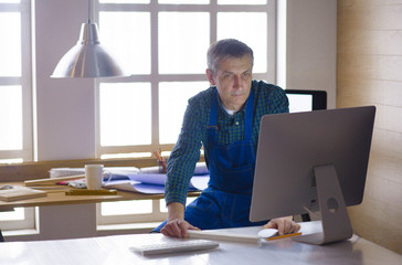 Engineer carpenter working on laptop and sketching project