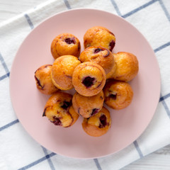 Top view, homemade mini muffins with cherry on pink plate. Flat lay, overhead, from above.