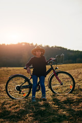 Obraz premium Cute little ten year old girl riding bicycle on countryside.