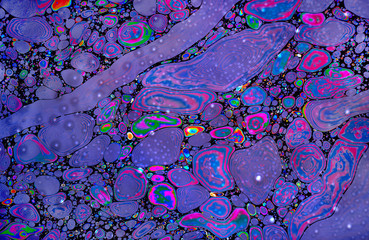 psychedelic colorised stains of gasoline or oil on the water