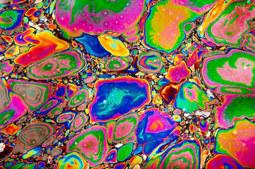 psychedelic colorised stains of gasoline or oil on the water