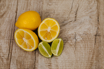 Fototapeta na wymiar half of lime and lemon on wood background