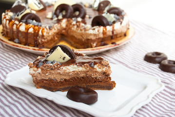 Slice homemade cake three chocolates with piece take out. Mousse glaze darkness decoration cake.