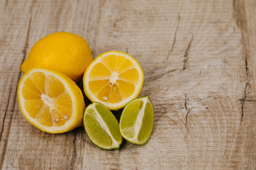 Fototapeta na wymiar half of lime and lemon on wood background