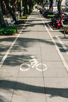 Bicycle lane mark on footpath with light and shadow of trees in Taipei, Taiwan.