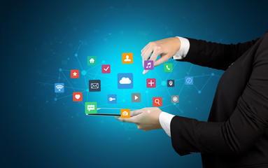 Female hand touching tablet with application icons above