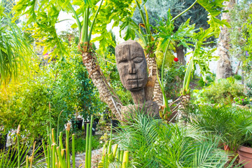 wooden idol in lushy green park at sunny day 