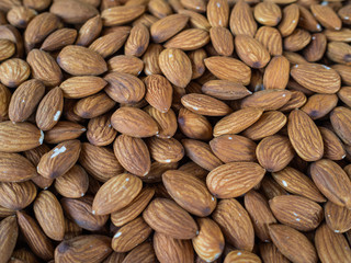 Set of the crude peeled almonds. A large number of nuts on a show-window of shop