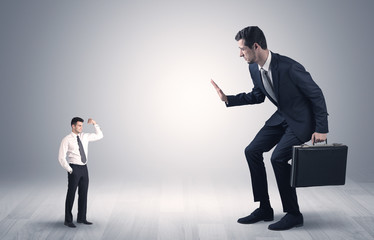 Big debutant young businessman scared of small strong businessman
