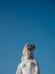 A marble statue in front of blue sky
