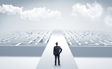 Businessman going straight ahead on a wide road between mazes

