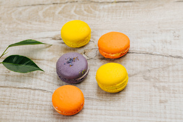 Cake macaron or macaroon on turquoise background from above, colorful almond cookies, pastel colors, vintage card, top view 