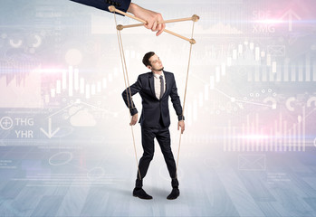 Puppet businessman controlled by another hand with financial concept
