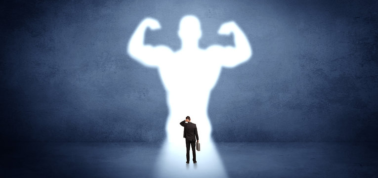 Businessman standing and dreaming about a strong superhero