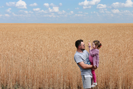 Father With His Daughter In A Wheat Field