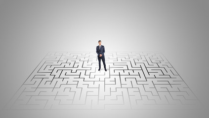 Elegant businessman looking for a solution in a middle of a maze

