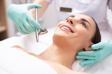 Face of smiling woman and oxygen spray treatment