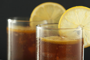 Glasses with cuba libre cocktail or cola with ice or cold tea with lemon