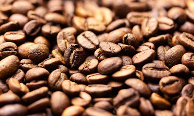 Pile of coffee beans texture, close up, dark background, shallow depth of field