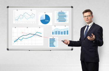 Handsome businessman presenting report on white board with laser pointer 
