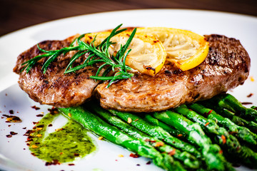 Grilled steak with asparagus on white background