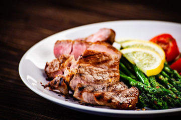 Grilled steak with asparagus on white background