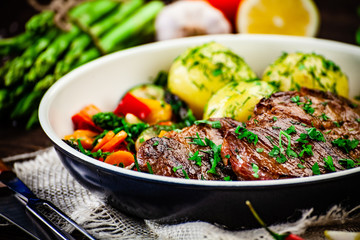 Grilled steak, boiled potatoes and vegetables
