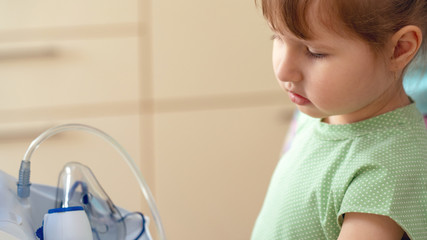 sick child sadly looks at the mask of the nebulizer