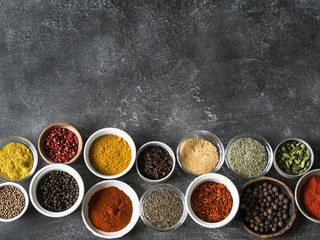 Various dry spices flat lay in small bowls on gray background. Top view, copy space