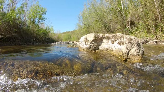 Water flowing on a river with rocks, panning shot, La Muga, Girona, Alt Emporda, Catalonia, Spain