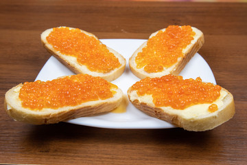 Sandwiches with butter and red caviar on a plate