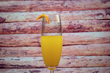 Mimosa cocktail (champagne with orange juice) in a glass of flute and orange zest