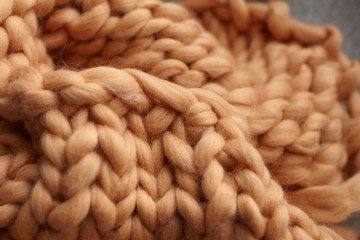 Merino wool handmade knitted large blanket, super chunky yarn, trendy concept. Close-up of knitted blanket, merino wool background. designer blanket made of beige smoky wool