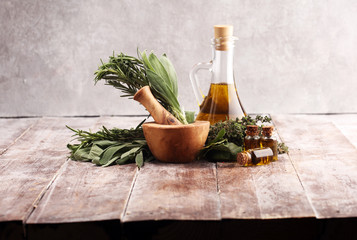Fresh herbs from the garden and the different types of oils for massage and aromatherapy on table © beats_