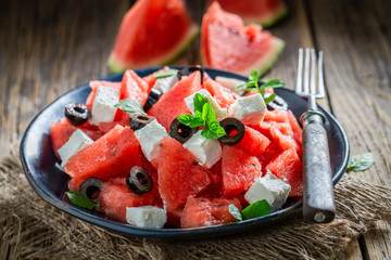 Healthy watermelon salad with feta, olives and mint leaves