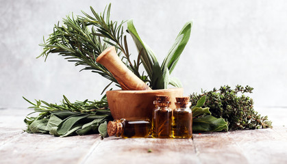 Fresh herbs from the garden and the different types of oils for massage and aromatherapy on table