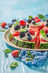 Fresh watermelon pizza with whipped cream and fresh berry fruits