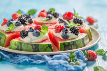 Homemade watermelon pizza with blueberries, raspberries and cream