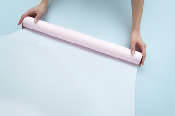 hands holding a roll of pink paper with space for text 
