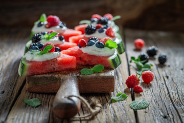 Healthy watermelon pizza with blueberries, raspberries and cream