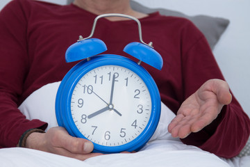 man in bed with alarm clock close up