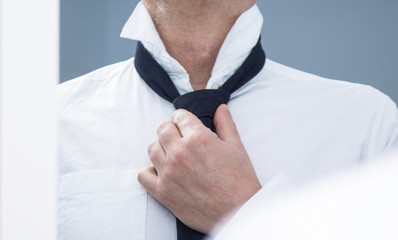 man in a suit fixing his tie